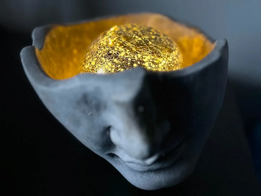 Figura de rostro humano con una bola luminosa en el interior simulando el cerebro, alusivo a los efectos de la marihuana en la memoria